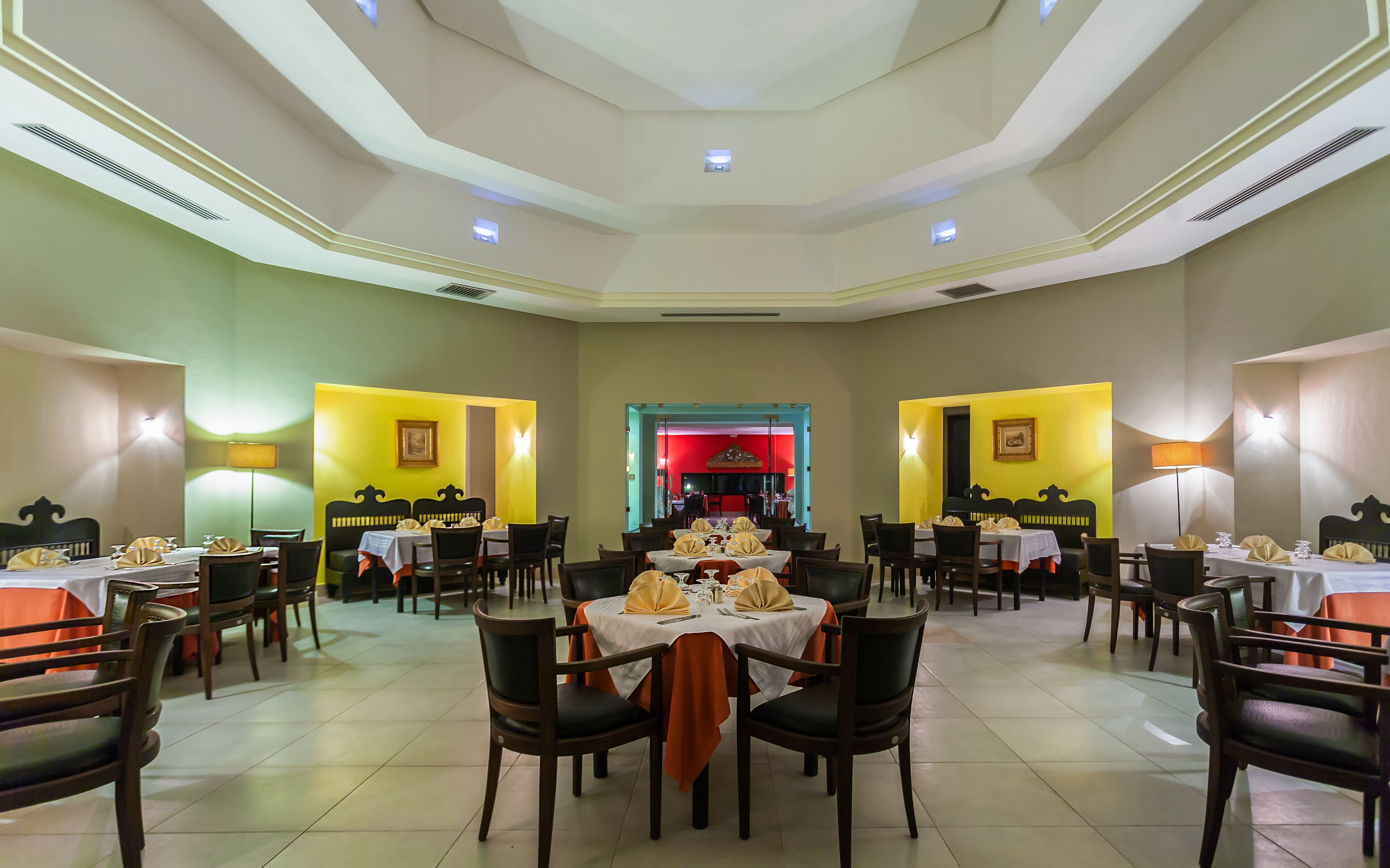 Comedor con varias mesas y sillas, dispuesto en un espacio amplio.