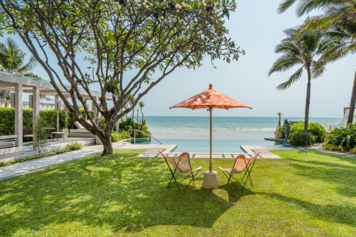 A well-maintained outdoor area with a pool, lounge chairs, and a view of the ocean.