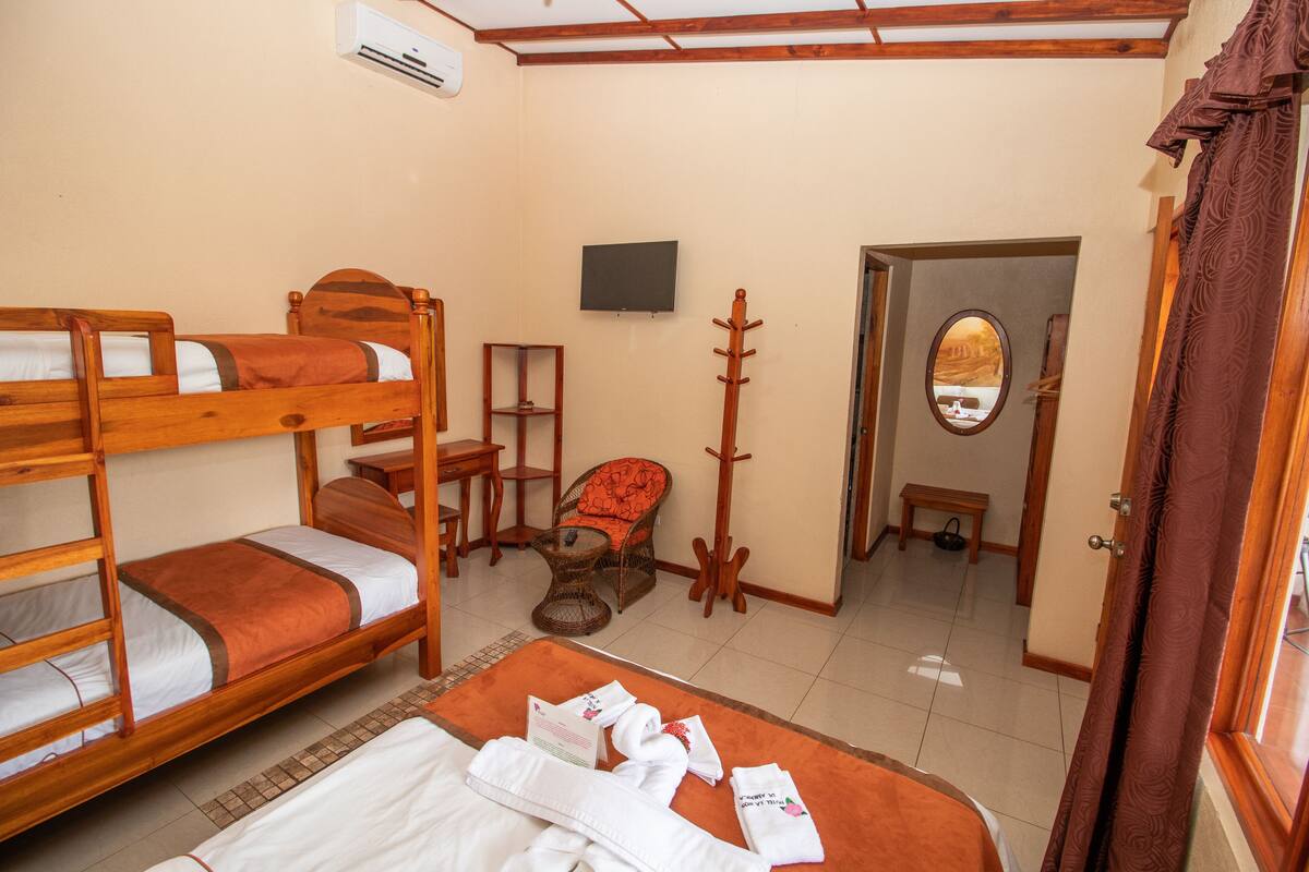 A room with bunk beds, a television, a mirror, and a small table.