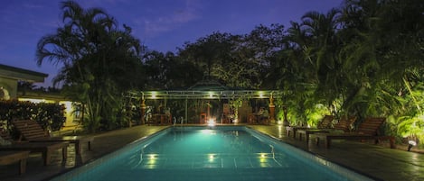 Una piscina al aire libre, tumbonas