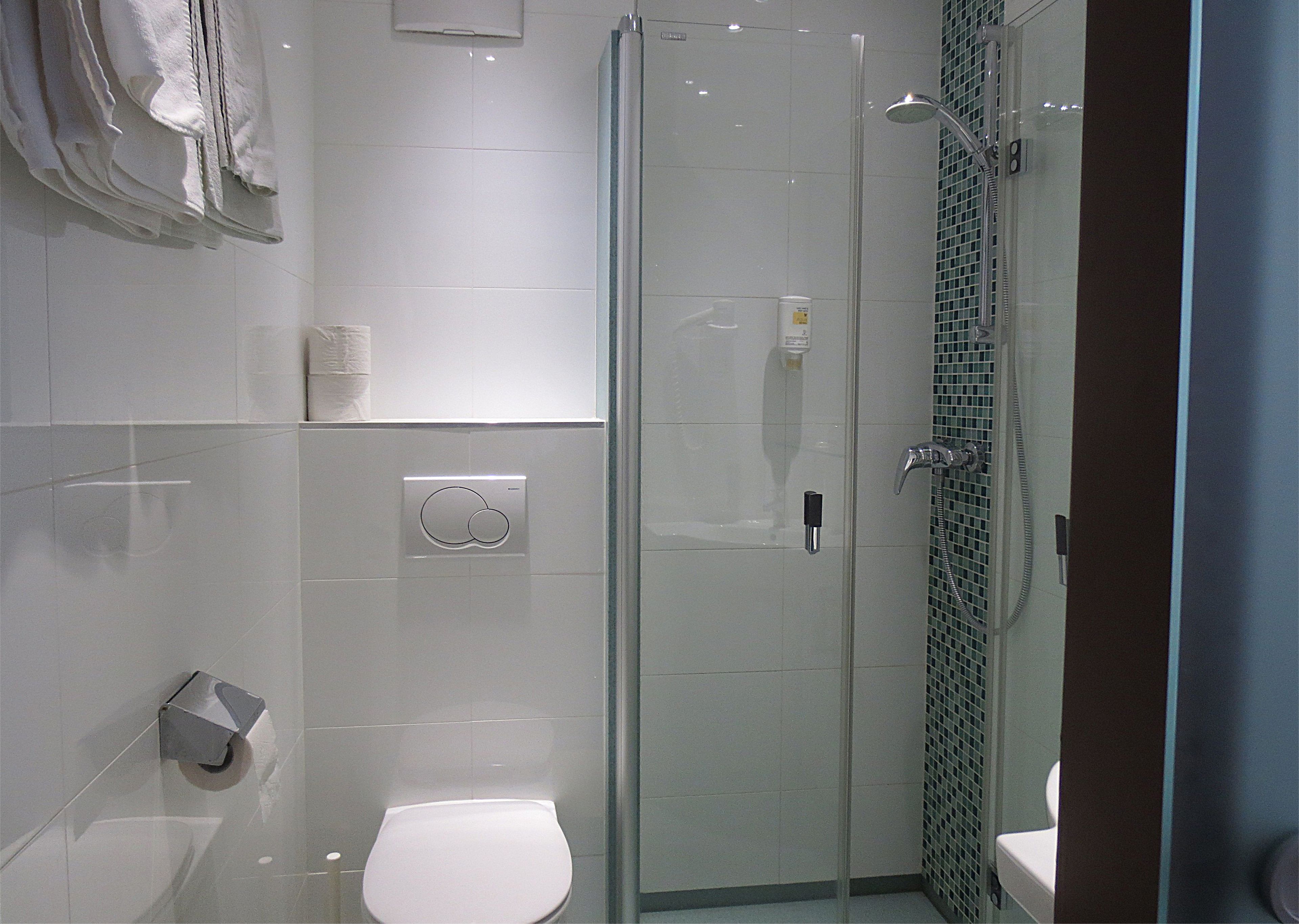 Un baño moderno con ducha de vidrio, inodoro y lavamanos.