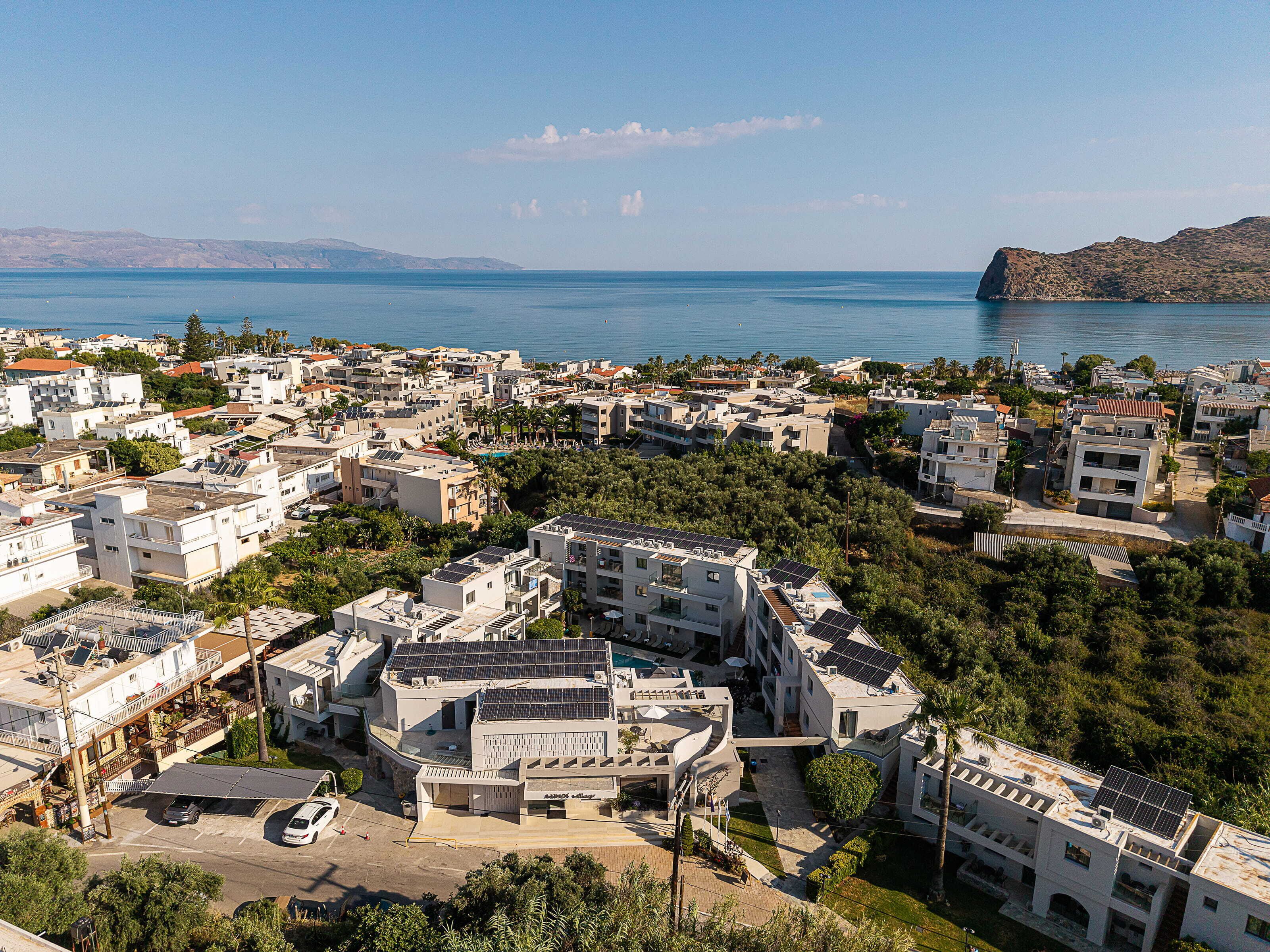 A coastal residential area with buildings, a swimming pool, and a view of the sea.