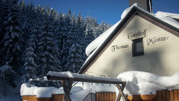 A snow-covered building with a sign reading "Gasthof Thomas Münzer". - Gasthof Thomas-Müntzer (Neuhaus am Rennweg)