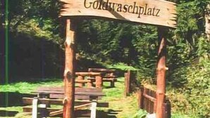 A wooden sign with the text "Goldwaschplatz" indicating a location. - Gasthof Thomas-Müntzer (Neuhaus am Rennweg)