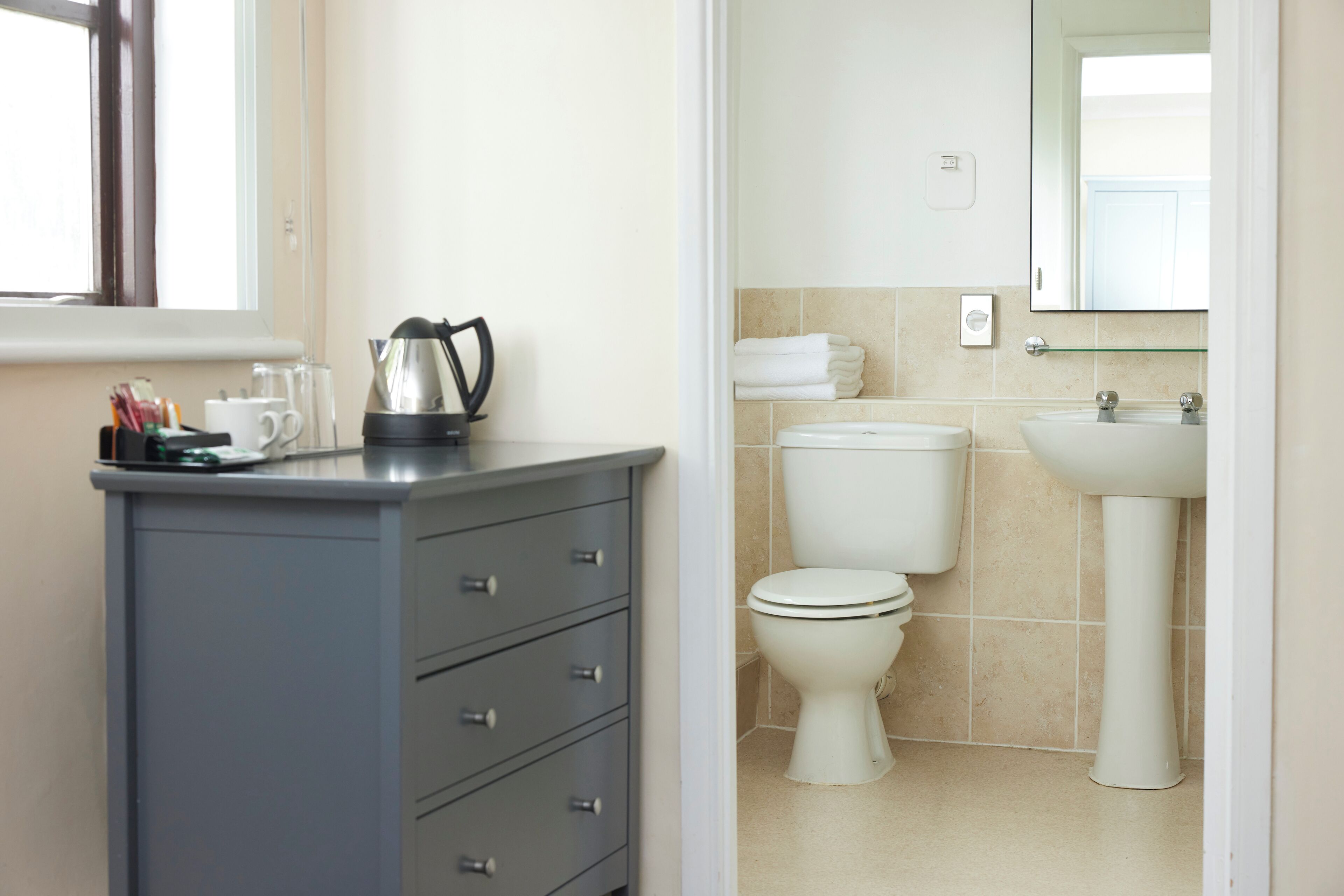 A bathroom with a toilet, sink, and cabinet.