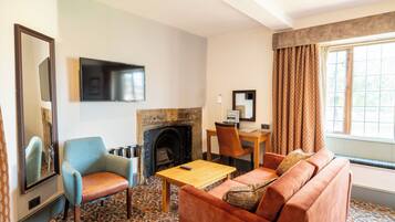 A living room with a fireplace, a television mounted on the wall, a sofa, a chair, and a table.