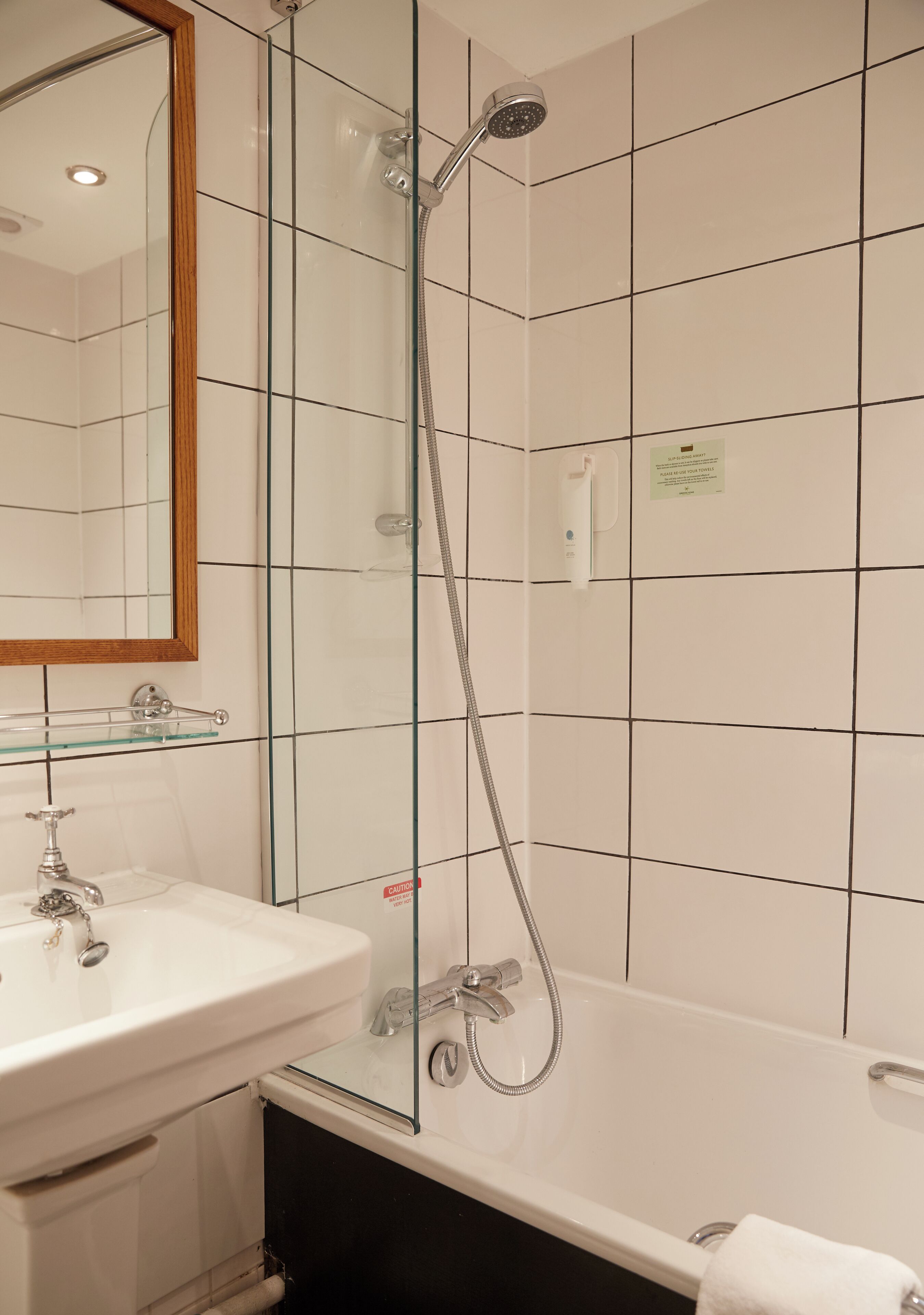 Un baño con ducha de vidrio, lavamanos blanco y bañera.