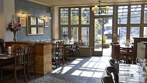 Un restaurant avec des meubles en bois, de grandes fenêtres et un sol à motifs.