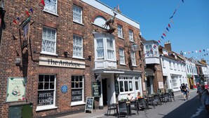 A brick building with a sign reading "The Antelope" and a signboard for a hotel lounge. There are tables and chairs outside the building. - Antelope Hotel by Greene King Inns (Poole)