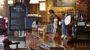 A bar area with a wine list, a beer tap, and a menu board. - White Hart Hotel by Greene King Inns (Colchester)