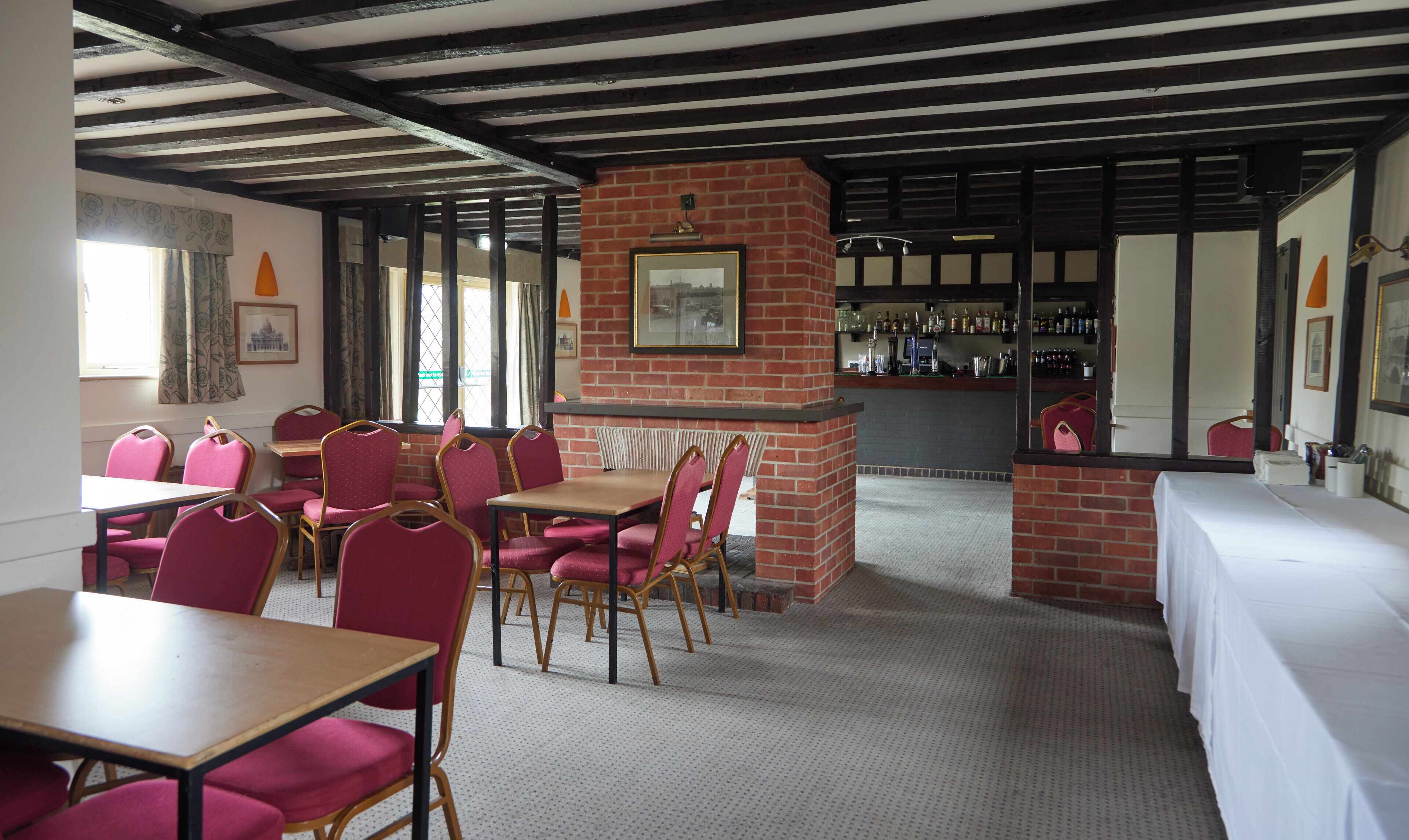A restaurant with brick walls, wooden beams, and a bar area.