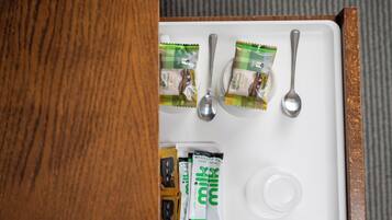 A tray with two packets of All Butter Shortbread and two spoons, along with a small container.