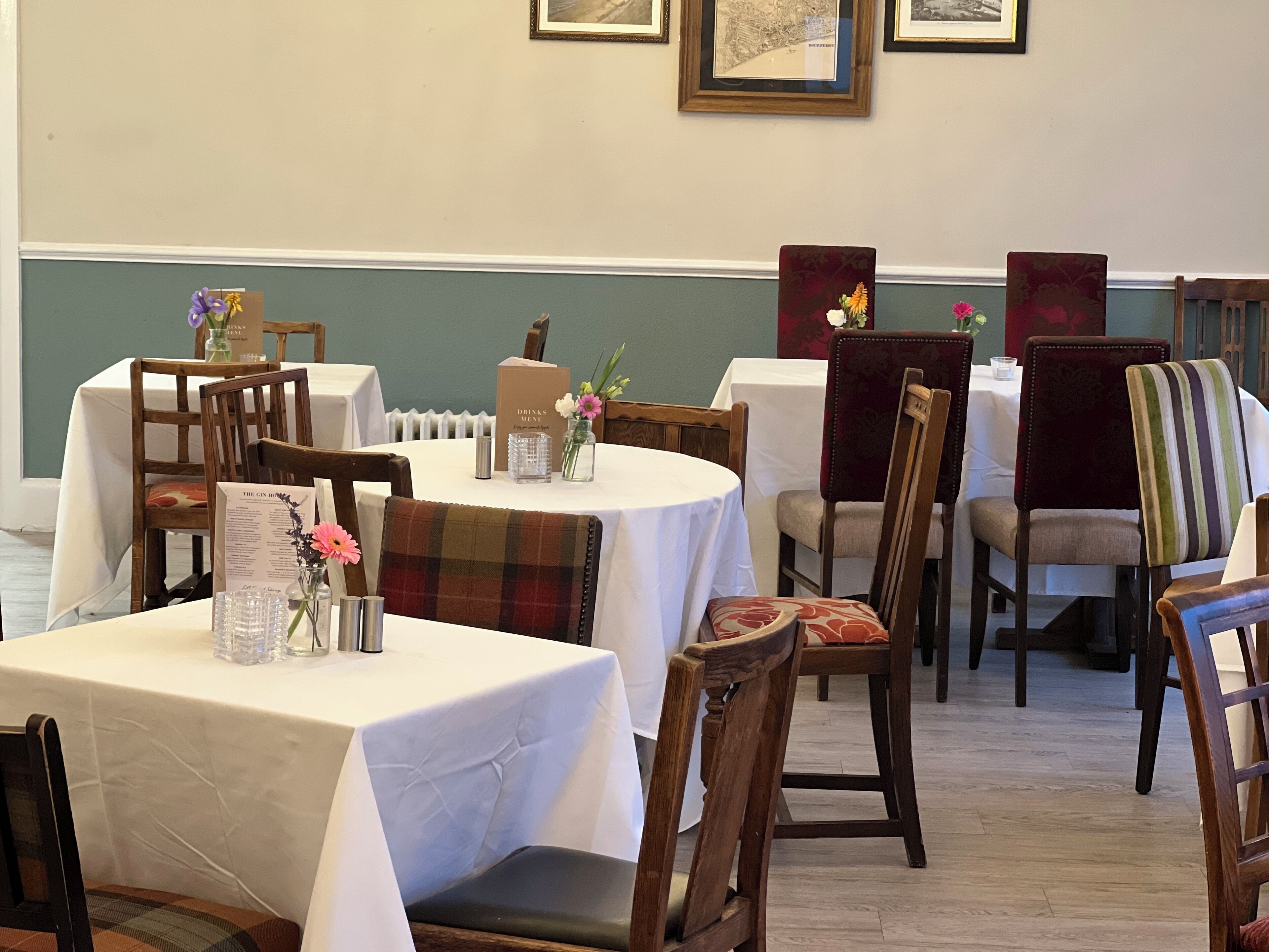 Un comedor con mesas y sillas, un menú y una caja con la etiqueta 'Drinks Menu'.