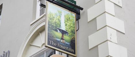 A building with a sign for "The Fountain" and "Old English."