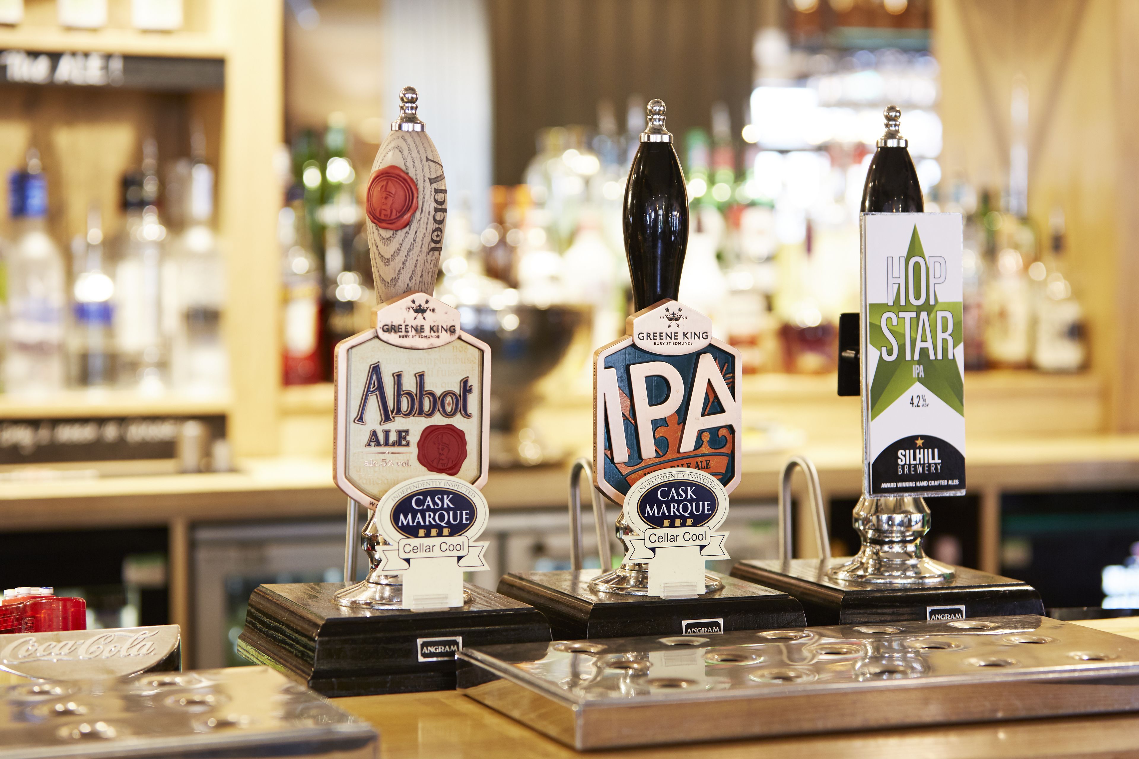 Tres grifos de cerveza etiquetados como Abbot Ale, IPA y Hop Star IPA.