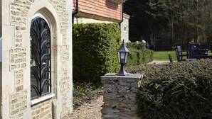 Un edificio in pietra con un cartello che riporta la scritta "DOG HOUSE" e un cancello in ferro battuto nero.