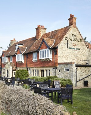 Un edificio tradicional con un letrero que dice "The Dog House Greene King".