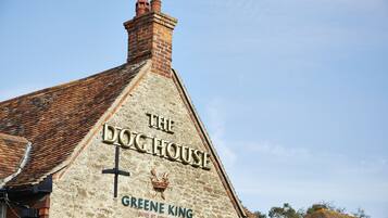 A building with a sign reading "The Doghouse" and "Greene King" on its facade.
