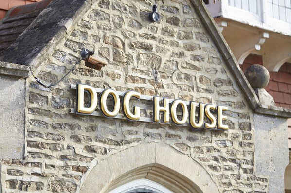 Un edificio de piedra con un letrero que dice "DOG HOUSE".