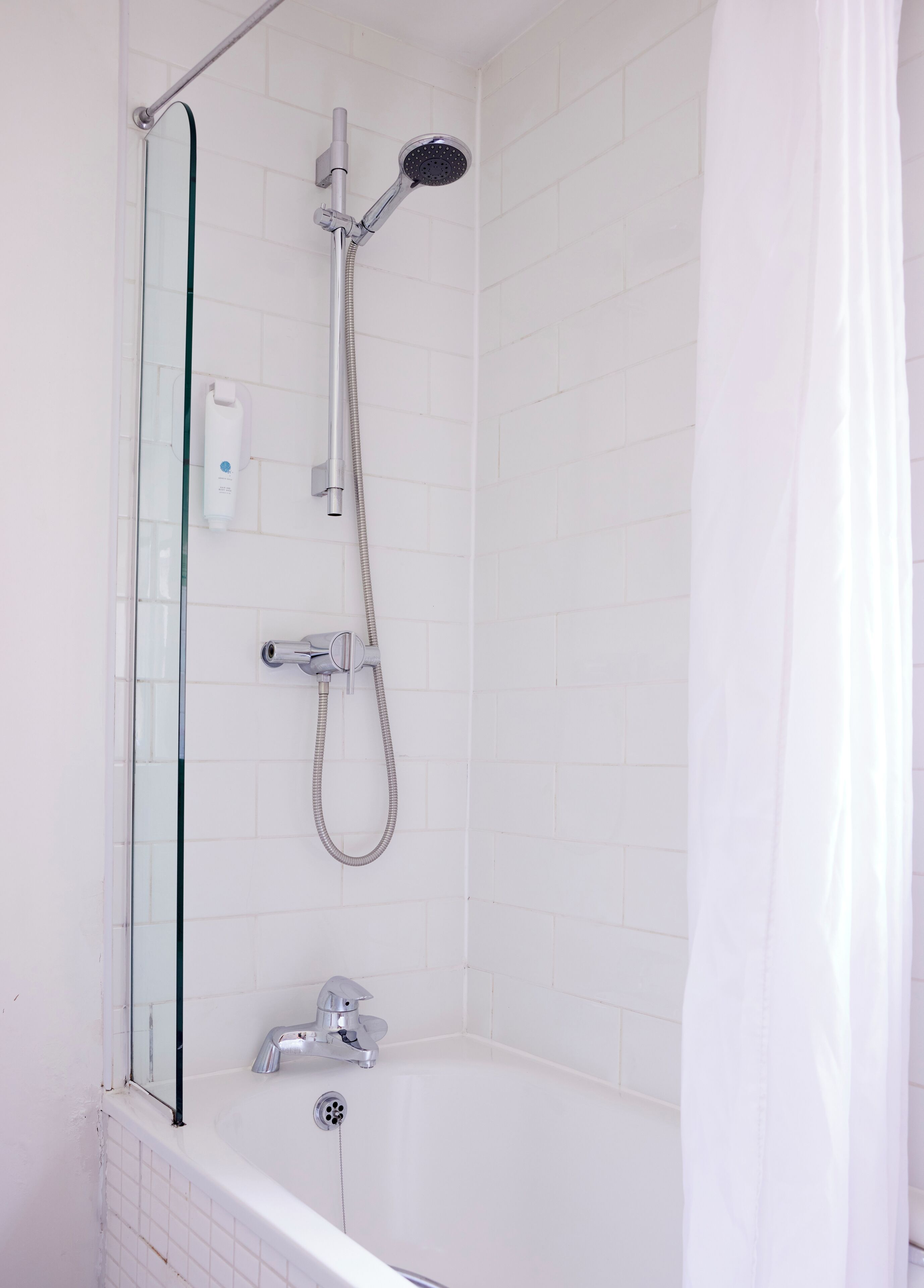 Ein modernes Badezimmer mit einer Glaskabine zur Dusche, einer freistehenden Badewanne und einer Duschbrause.