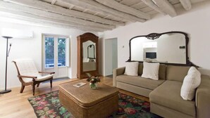 A living room with a sofa, a chair, a coffee table, and a mirror. - BB 22 Charming Rooms & Apartments (Palermo)