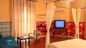 A hotel room with a bed, a TV, a chair, and a small table. - Prince of Via Veneto DELUXE (Rome)