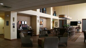 A spacious lobby with multiple seating areas, a coffee station, and a television. - Hampton Inn & Suites Pueblo/North (Pueblo)