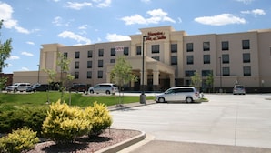 A Hampton Inn & Suites hotel with a parking lot, several cars, and a clear sky. - Hampton Inn & Suites Pueblo/North (Pueblo)