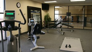 A hotel fitness center with cardio machines, dumbbells, and a mirror. - Hampton Inn & Suites Pueblo/North (Pueblo)