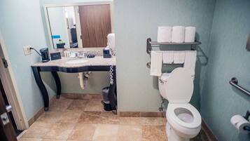 A bathroom with a sink, mirror, toilet, and towel rack.