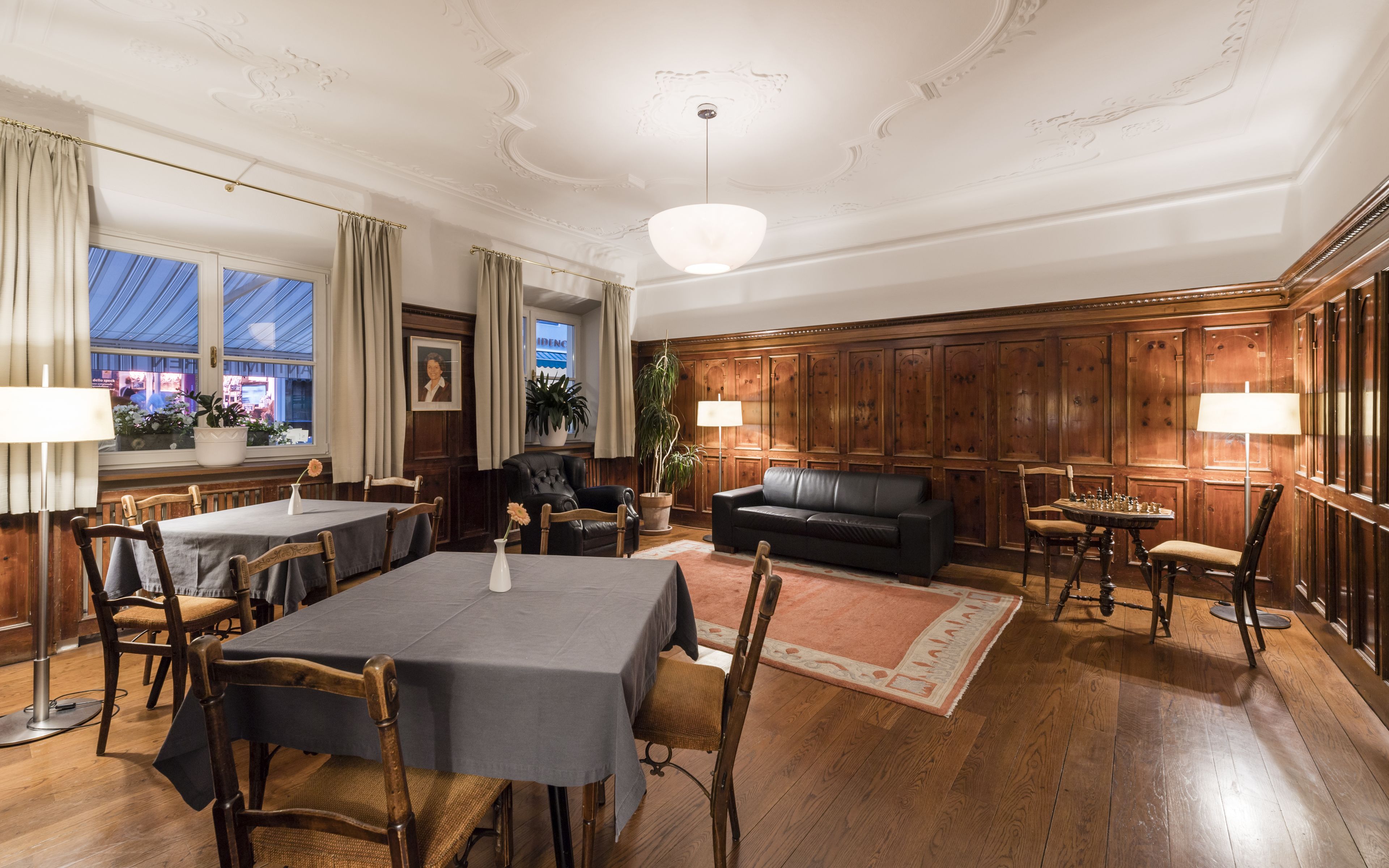 En elegant spisesal med et højt bord, stole og en sofa.