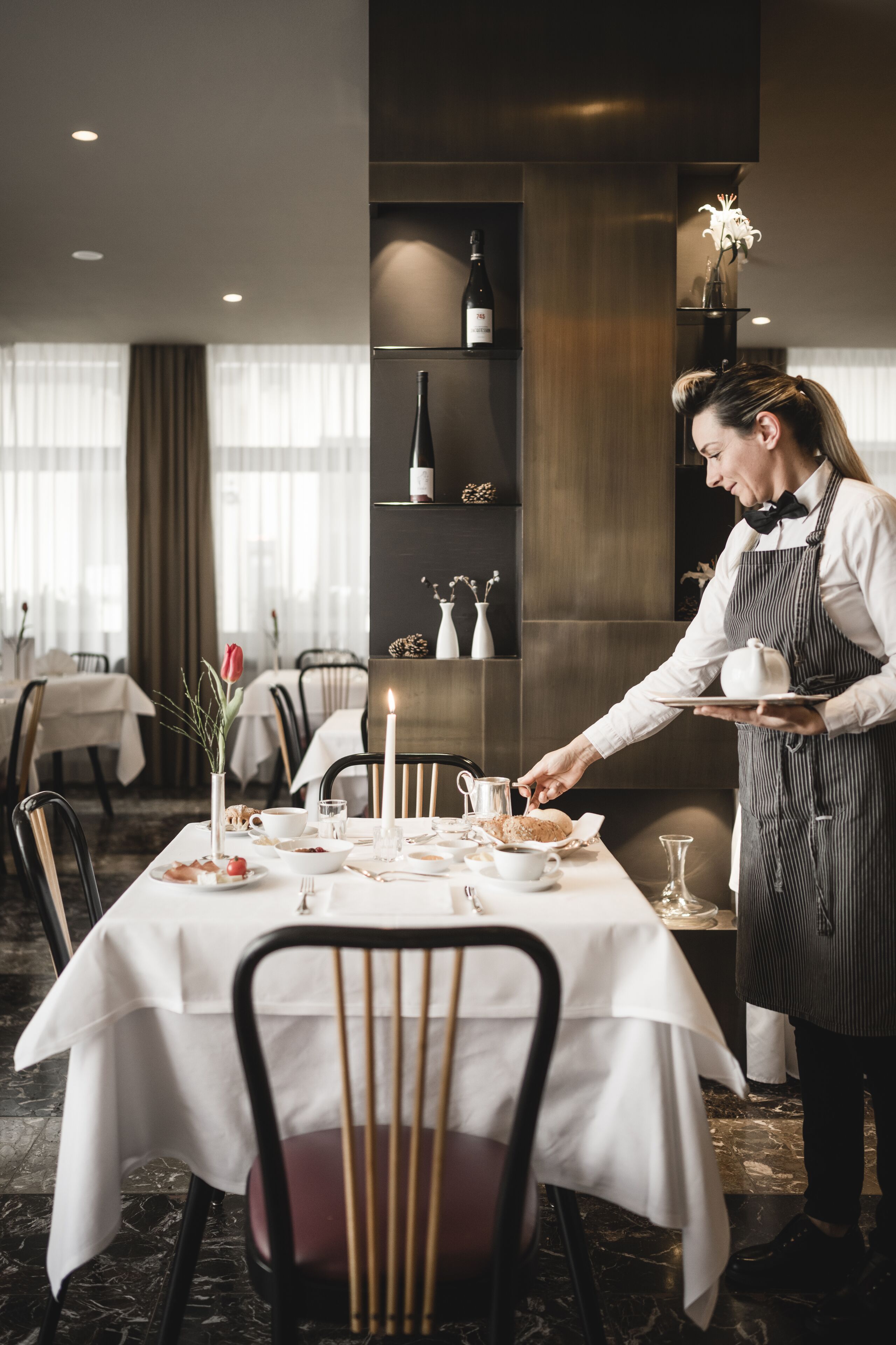 A restaurant setting with a waiter serving a table.