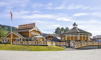 A hotel with a prominent sign, a flagpole, and a small tower.