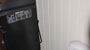 A compact, dark-colored refrigerator with a control panel and a small air conditioning unit beside it.