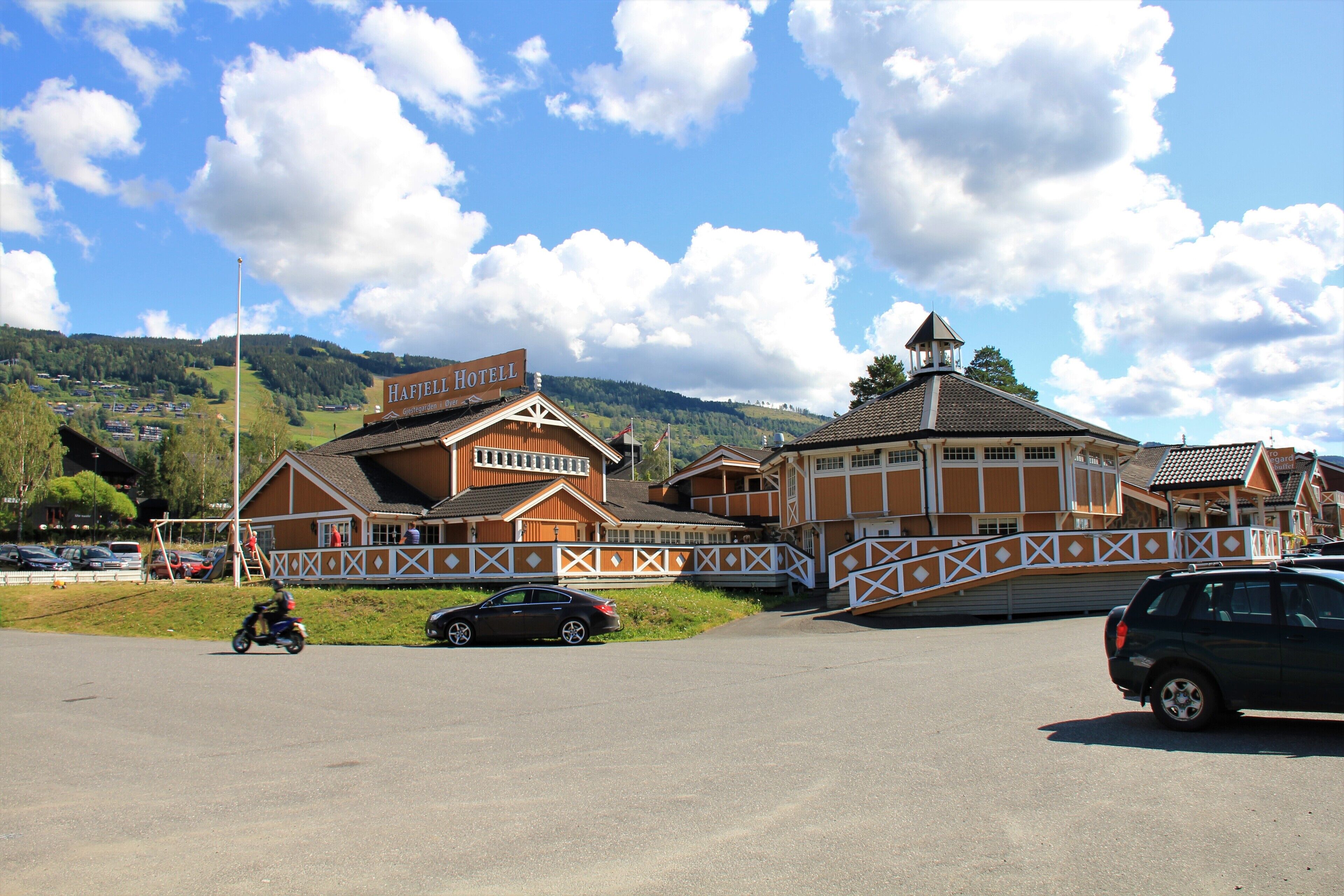 A hotel with a traditional wooden facade, a prominent sign, and a balcony.
