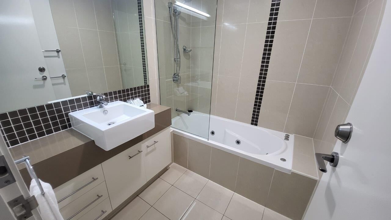 Ein modernes Badezimmer mit einer Duschkabine, einem Doppelwaschtisch und einer Badewanne.