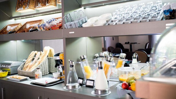 A breakfast buffet with bread, pastries, and fruit juices. - Top Motel (Istres)