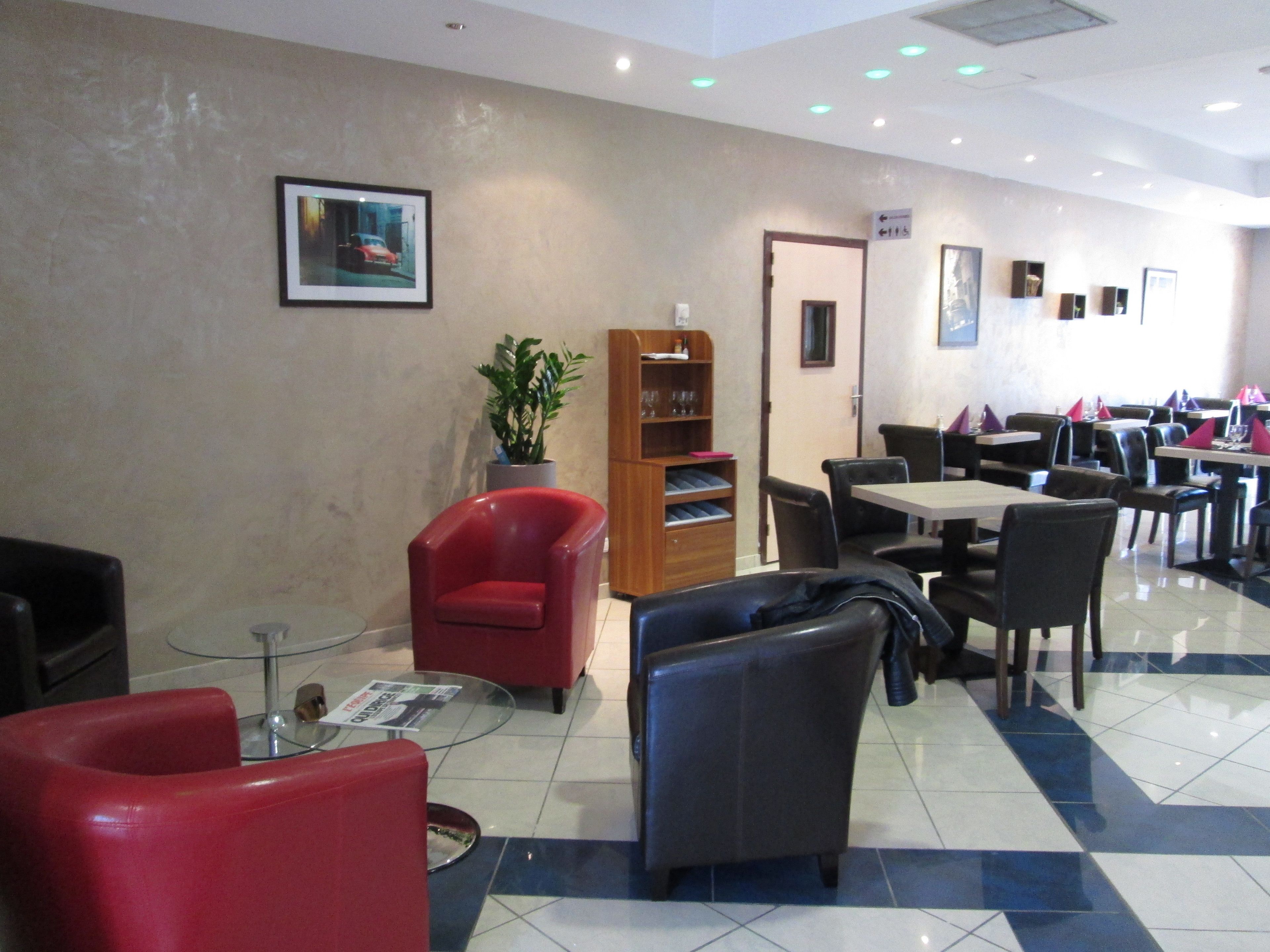 En hotellobby med en receptionsdisk, en sittgrupp och en matplats.