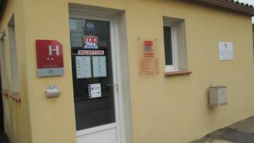 Una recepción de hotel con un letrero que indica 'Top Motel' y 'Recepción'.