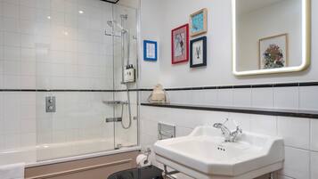 A modern bathroom with a glass-enclosed shower, a white sink, and a toilet.
