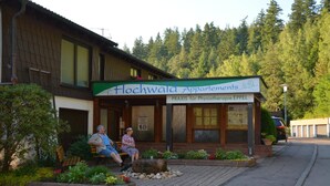 A building with a sign reading "Hochwald Apartments" and "PRAXIS für Physiotherapie EPPEL". - Aparthotel Hochwald (Bad Liebenzell)