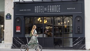 Fachada de hotel con el nombre "HOTEL DE FRANCE" y "GARE DE LYON" a la vista.