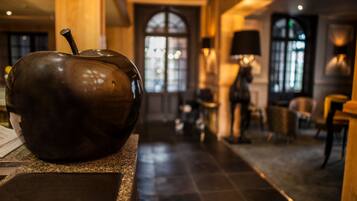 A modern interior with a large bronze sculpture on a counter, a grand arched doorway, and elegant lighting fixtures.