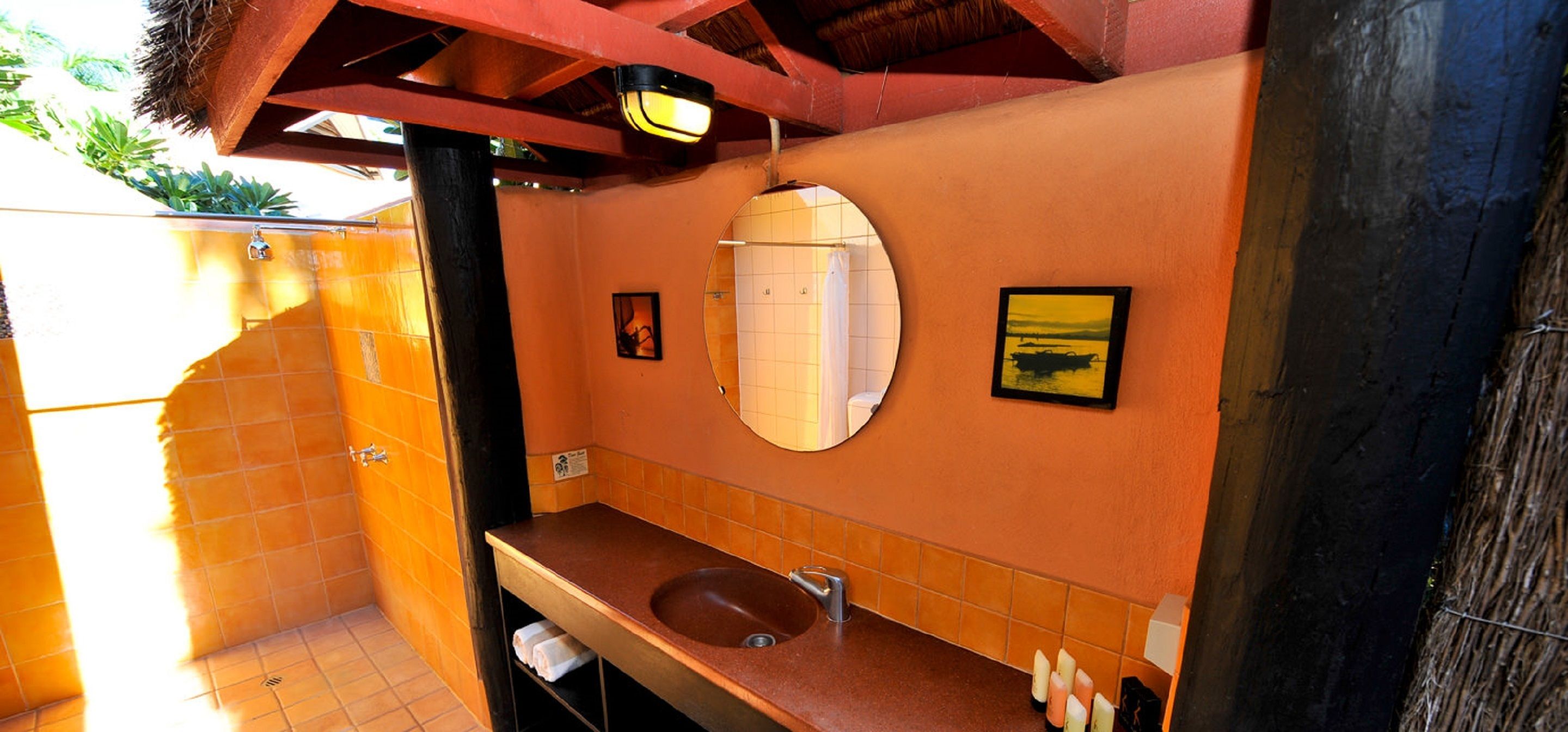 Ein Badezimmer mit großem Spiegel, Waschbecken und Duschbereich.