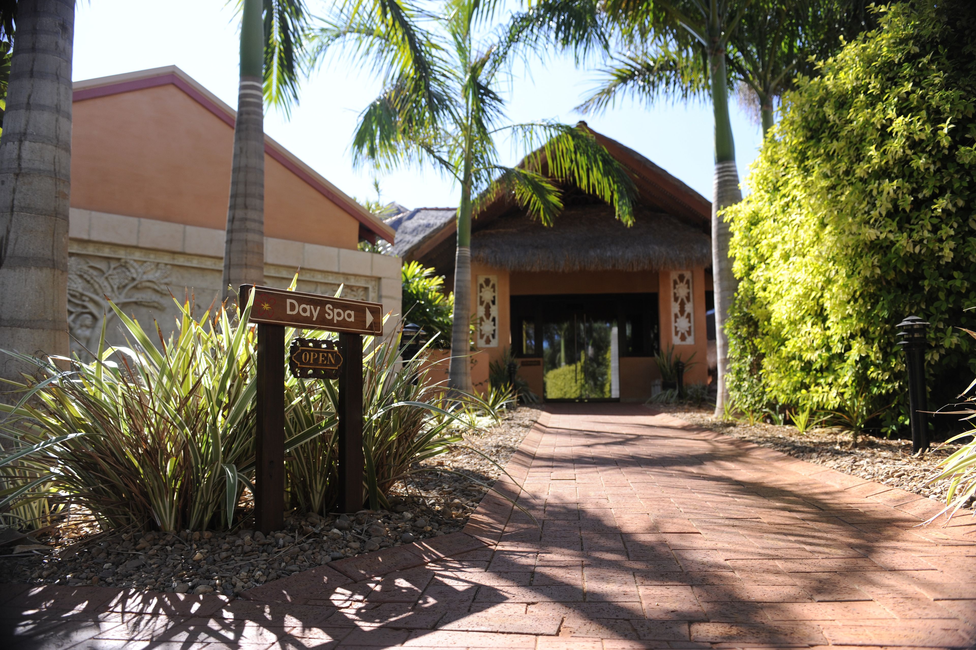 A pathway leading to a building with a sign indicating 'Day Spa' and 'Open'.