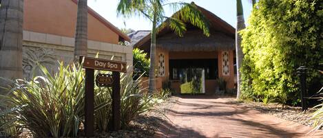 A pathway leading to a building with a sign indicating 'Day Spa' and 'Open'.