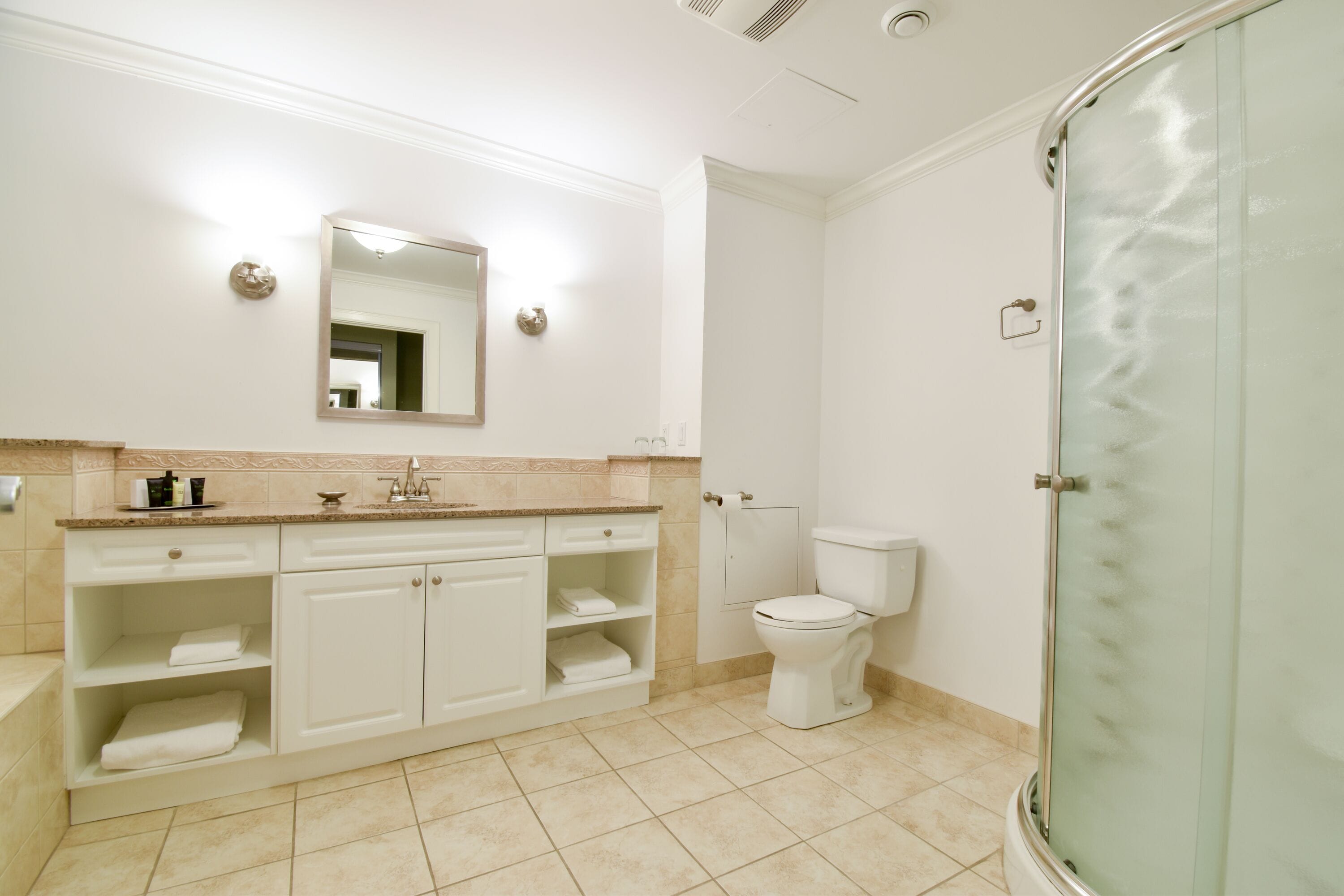 Une salle de bain moderne avec un lavabo, un miroir et des toilettes, le tout de couleur blanche.