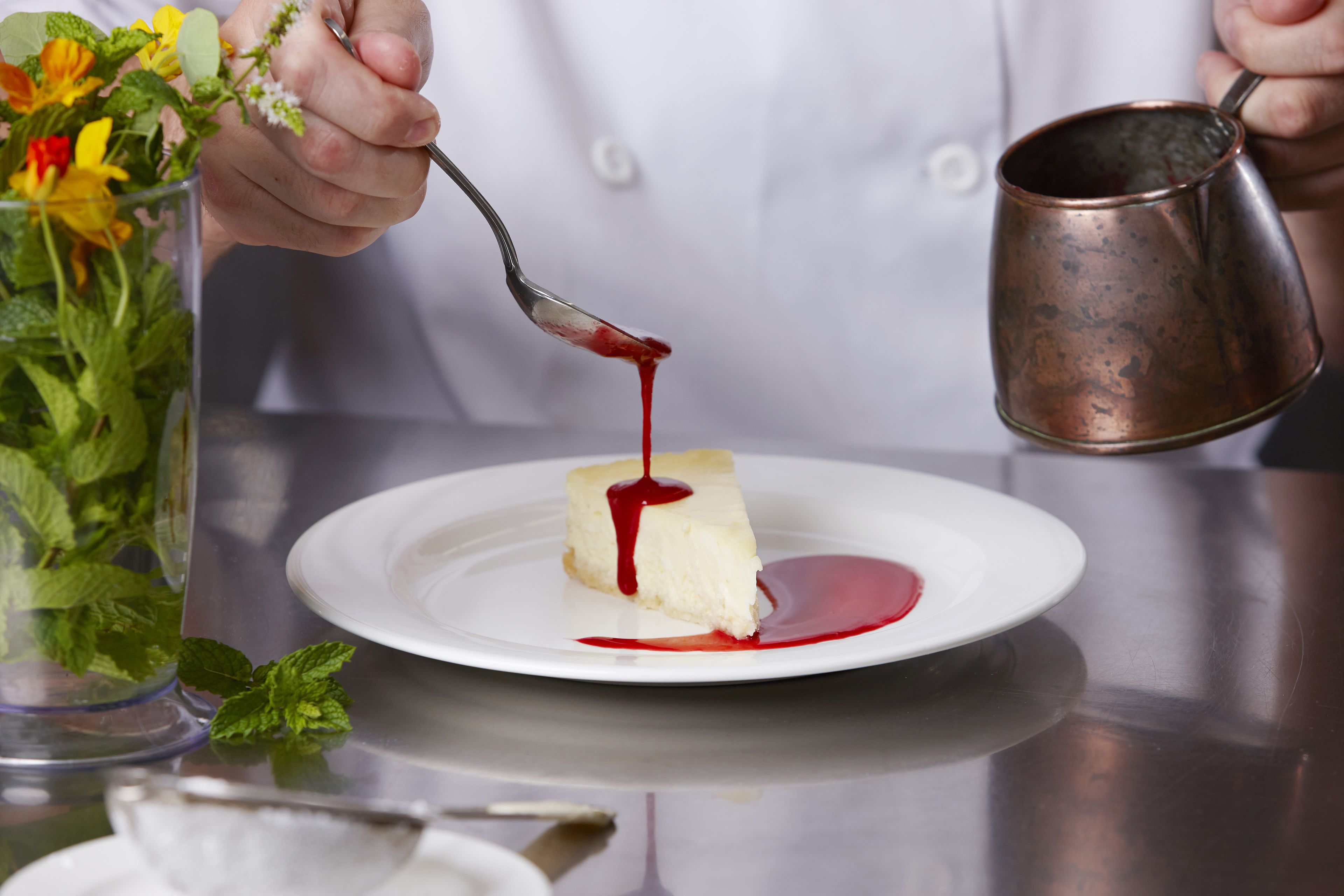 Dessert med rød sauce hældes på en tallerken.