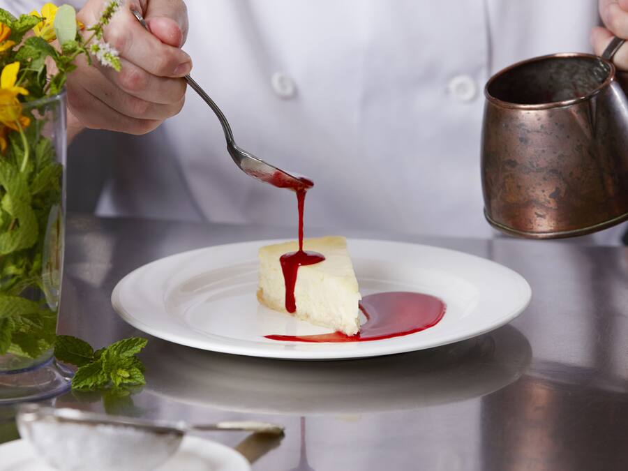 Dessert med rød sauce hældes på en tallerken.