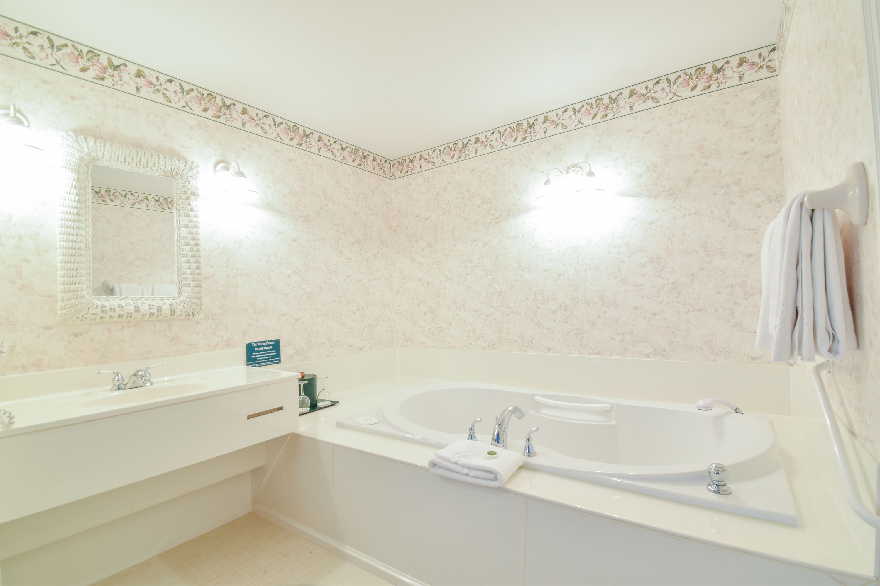 Une salle de bain avec une grande baignoire, un double vasque et un miroir.